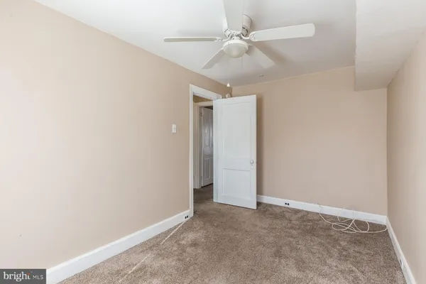 an empty room with a ceiling fan and a window