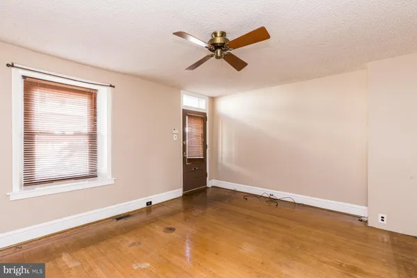 an empty room with a window and a ceiling fan