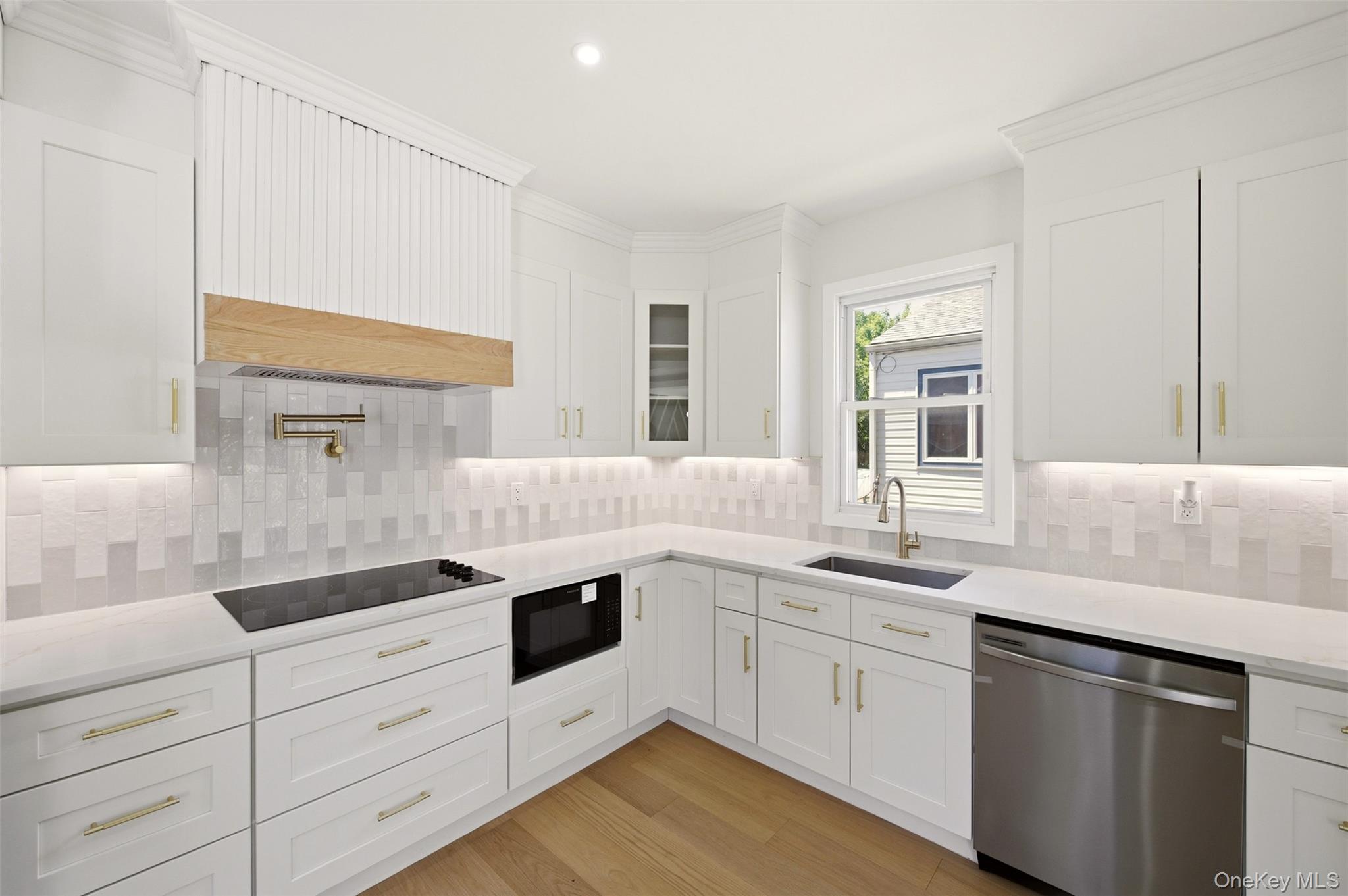 135 Whaley Street Freeport, NY 11520 - Photo 20 of 38 a kitchen with granite countertop white cabinets and white appliances