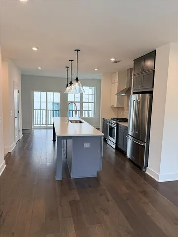 a kitchen with kitchen island wooden floor center island and stainless steel appliances