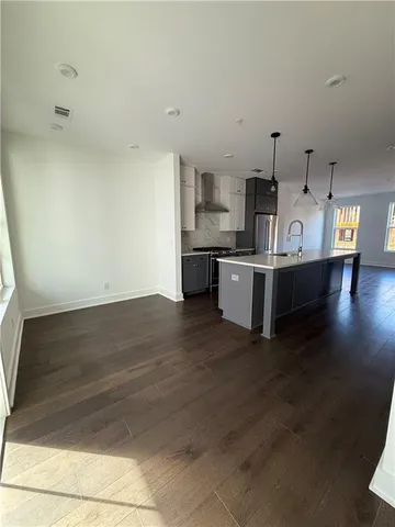 a large kitchen with stainless steel appliances a large counter top and stove