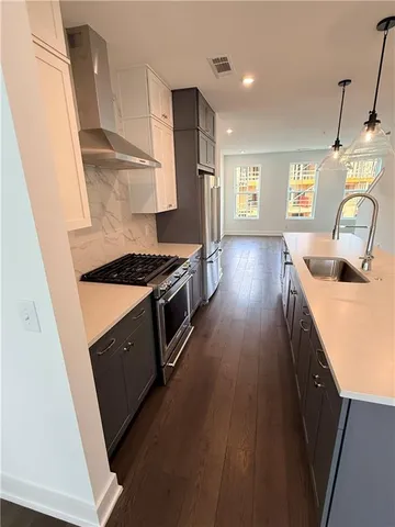 a kitchen with granite countertop a sink stove and refrigerator