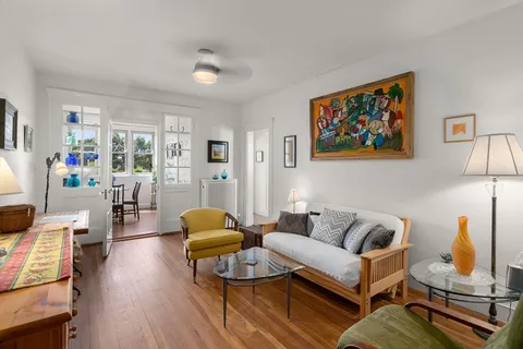 a view of a livingroom with furniture wooden floor and windows