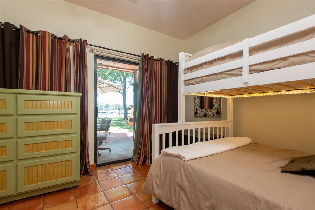 121 Xit Ranch Road Trinidad, TX 75163 - Photo 17 of 40 This room features terra cotta tile flooring and a glass sliding door providing access to an outdoor patio with a viwater views