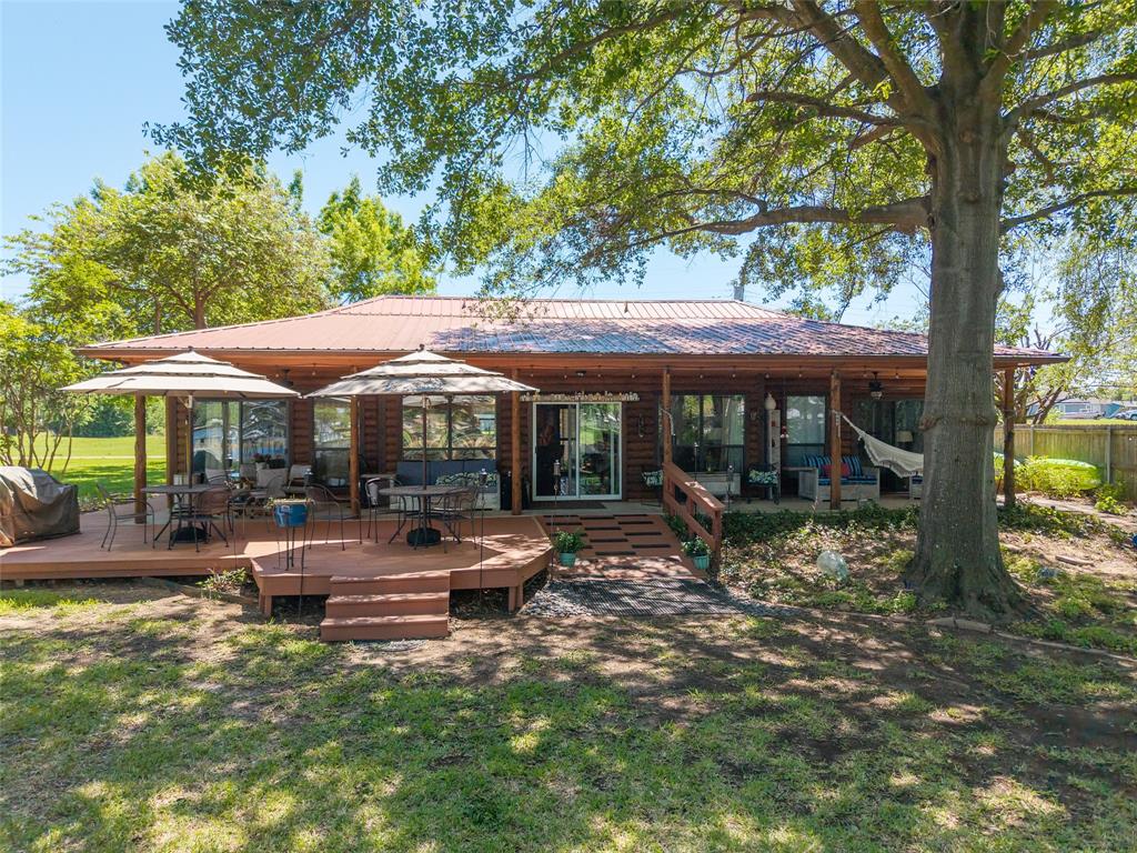 121 Xit Ranch Road Trinidad, TX 75163 - Photo 26 of 40 The property features a spacious rear deck with outdoor seating areas, a covered porch, and a large yard with mature trees