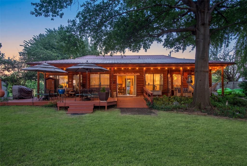 121 Xit Ranch Road Trinidad, TX 75163 - Photo 3 of 40 The property features a log cabin style exterior with a metal roof and an expansive wooden deck