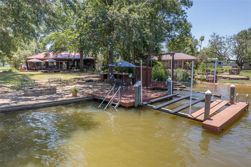121 Xit Ranch Road Trinidad, TX 75163 - Photo 35 of 40 Waterfront property featuring a private boat dock with a lift, a separate patio area with a fire pit, and a spacious deck overlooking the water