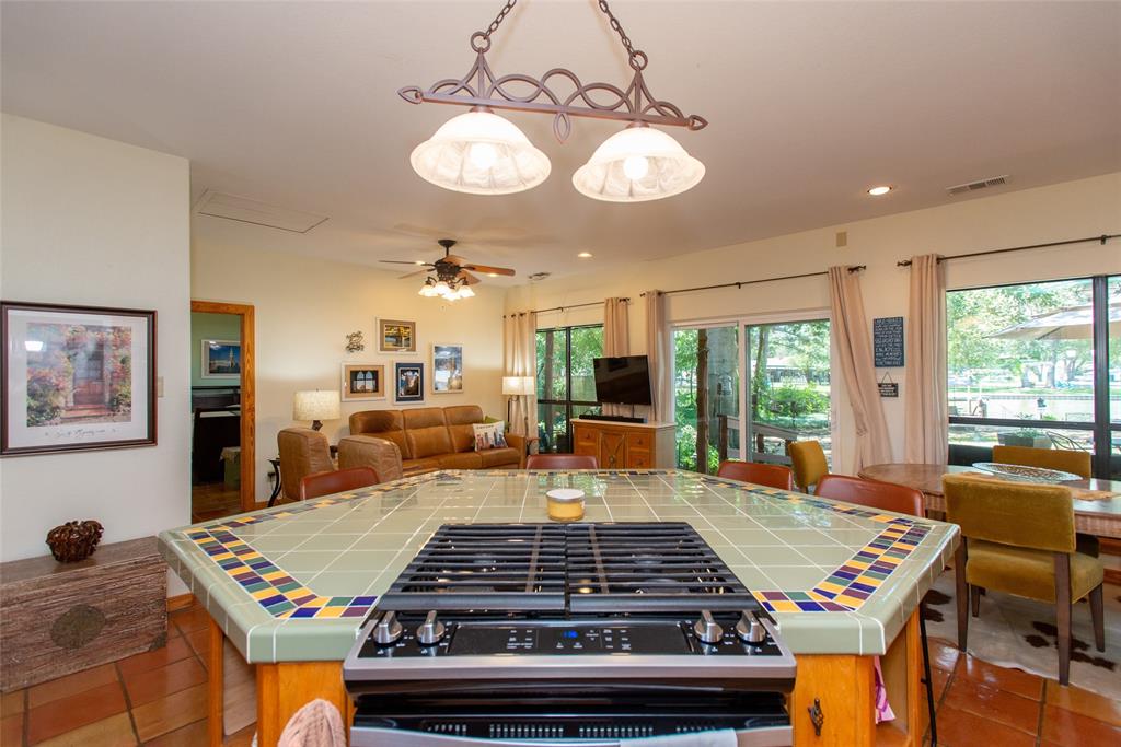 121 Xit Ranch Road Trinidad, TX 75163 - Photo 9 of 40 The kitchen features a tiled island with a gas range, providing a central cooking area