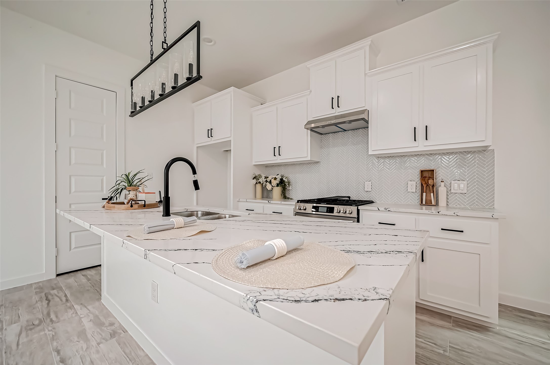 a kitchen with kitchen island a sink a stove and cabinets