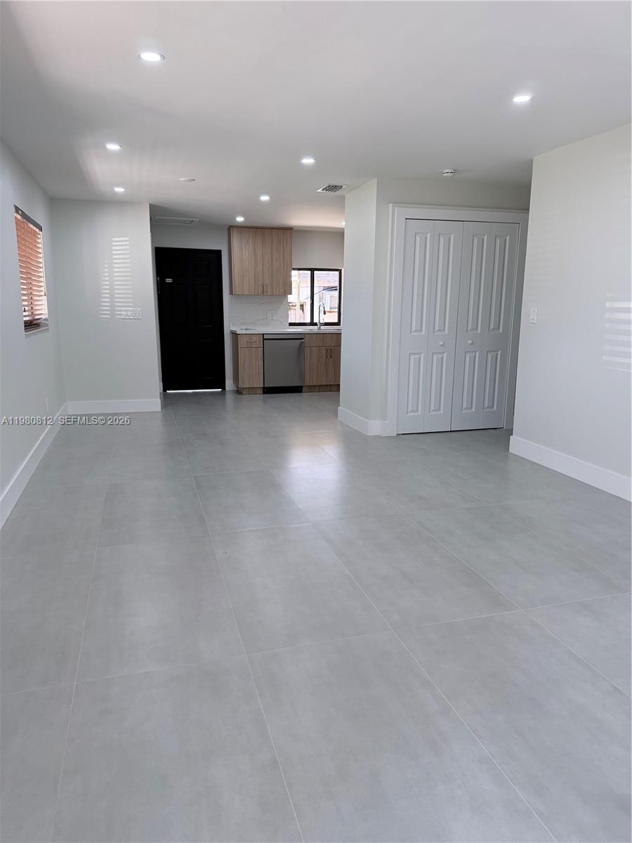 7801 Southwest 12th Street, Unit 7801 Miami, FL 33144 - Photo 3 of 12 an empty room with a kitchen and entryway