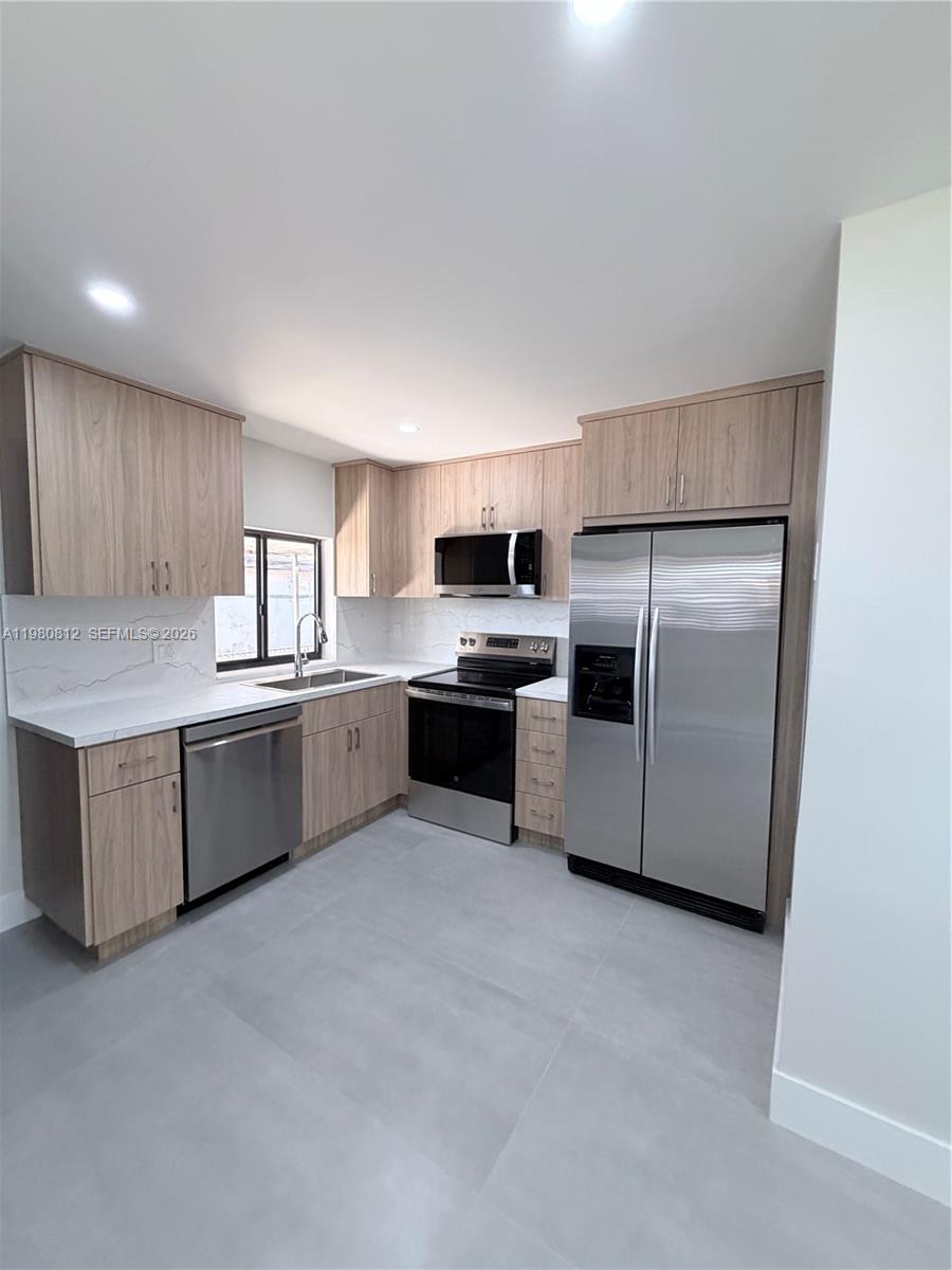 7801 Southwest 12th Street, Unit 7801 Miami, FL 33144 - Photo 4 of 12 a kitchen with stainless steel appliances a refrigerator sink and microwave