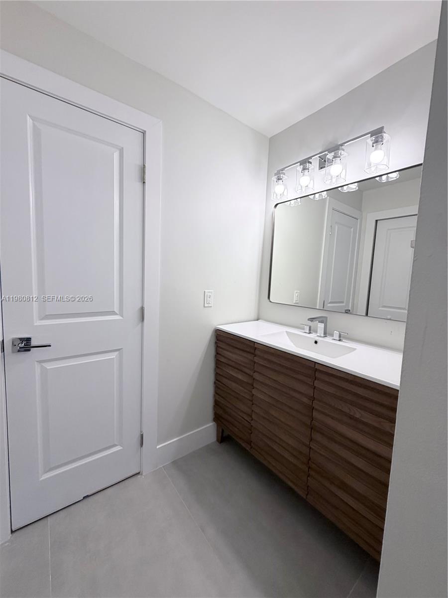 7801 Southwest 12th Street, Unit 7801 Miami, FL 33144 - Photo 9 of 12 a bathroom with a double vanity sink and a mirror