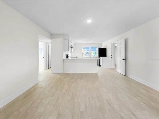 a view of empty room with wooden floor and window