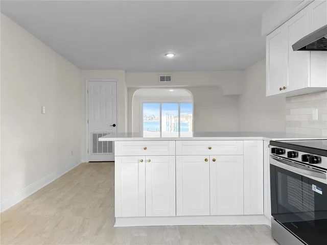 a kitchen with granite countertop white cabinets white stainless steel appliances and a sink