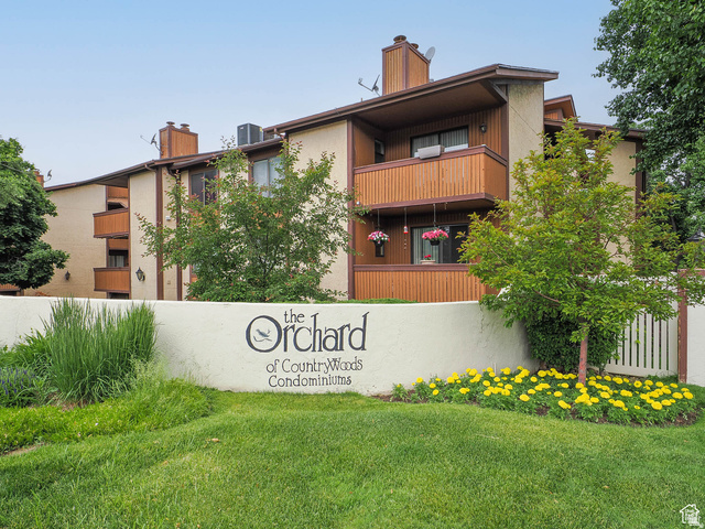 6852 Countrywoods Circle, Unit 5D Midvale, UT 84047 - Photo 2 of 50 Multi-story condominium building featuring light-colored stucco and brown wood-panel siding