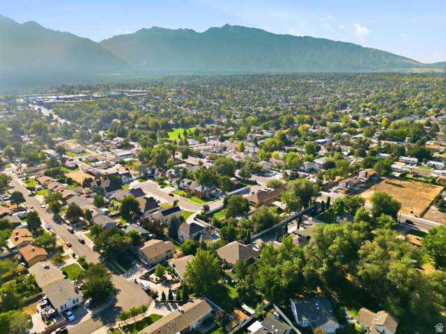 7772 South Rustic Cove Midvale, UT 84047 - Photo 38 of 39 Aerial view showcasing a residential neighborhood with mature tree canopy throughout, single-family homes on established lots, and mountain backdrop