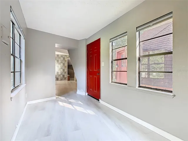 an empty room with wooden floor and window