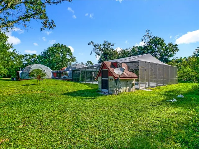 an aerial view of residential houses with outdoor space and trees all around