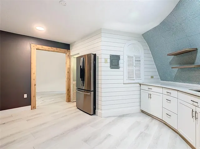 a view of a hallway with wooden floor and a living room