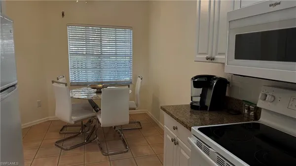 a view of a kitchen with granite countertop a sink and a stove top oven