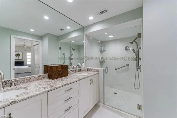 a spacious bathroom with a granite countertop sink mirror and shower