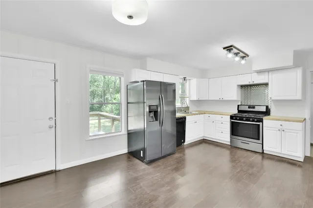 a kitchen with granite countertop white cabinets and stainless steel appliances