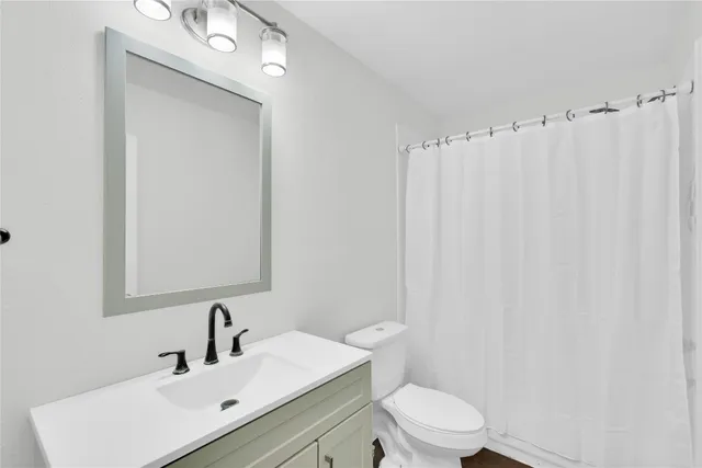 a bathroom with a toilet a sink and a mirror