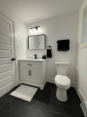a bathroom with a toilet a sink and mirror