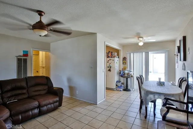 a living room with furniture a dining table and a chandelier