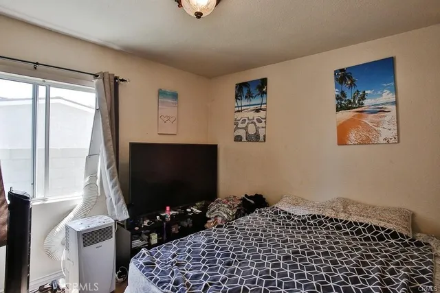 a bedroom with a bed and a flat screen tv