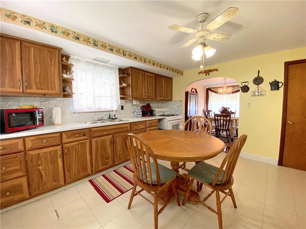 560 Center Hill Road Pittsburgh, PA 15239 - Photo 13 of 25 a kitchen with stainless steel appliances granite countertop a sink a stove a dining table and chairs