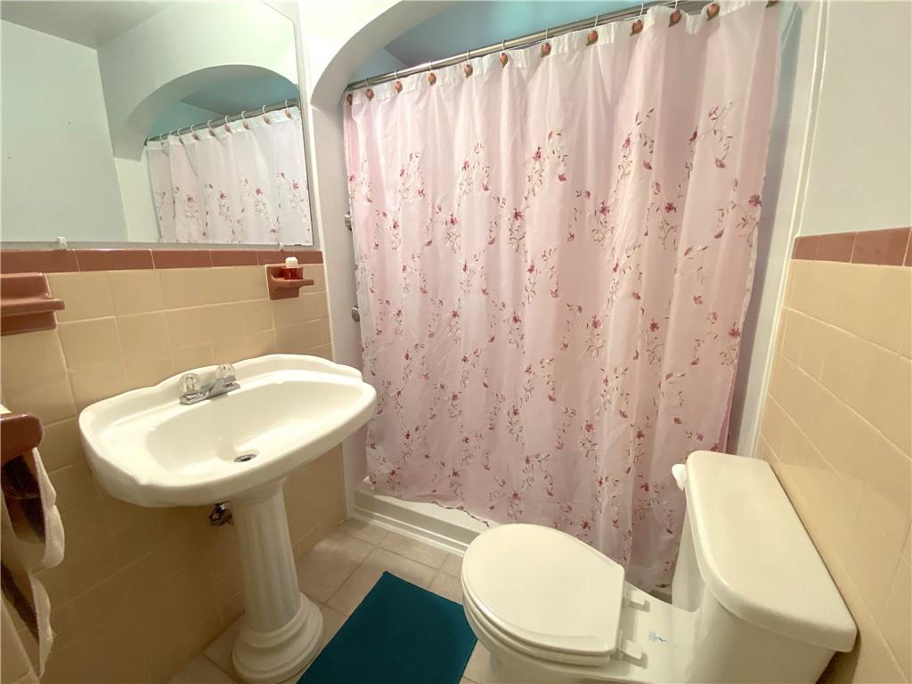 560 Center Hill Road Pittsburgh, PA 15239 - Photo 18 of 25 a bathroom with a sink a toilet and a mirror