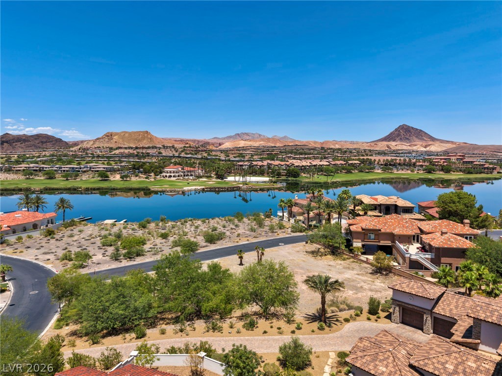 3 Rue Promenade Way Henderson, NV 89011 - Photo 8 of 26 An aerial panorama reveals stunning lake and golf course views with distant mountains under a cloudless sky.