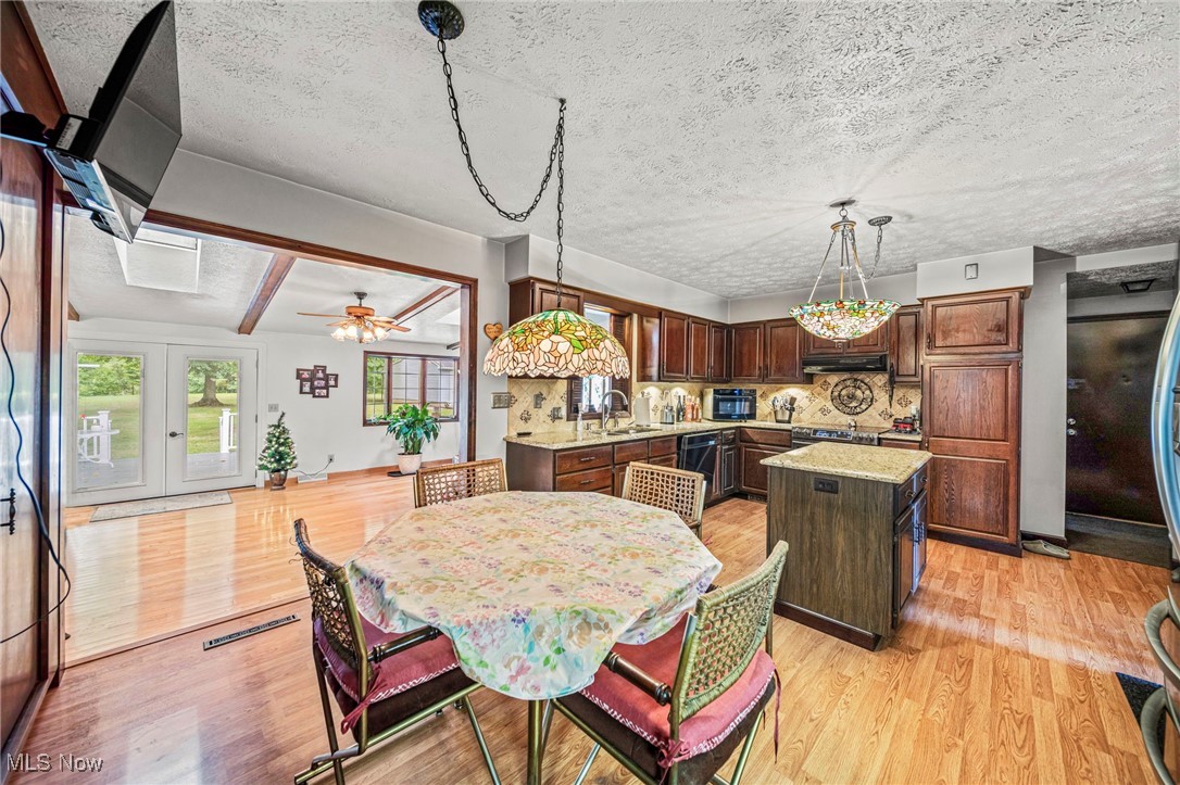 2921 Sexton Road Geneva, OH 44041 - Photo 23 of 43 Dining room with a textured ceiling, light wood finished floors, french doors, and ceiling fan