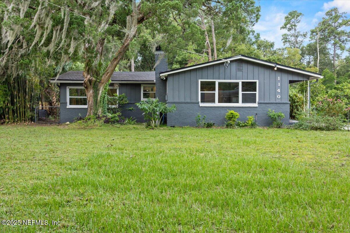 a view of a house with yard and a garden