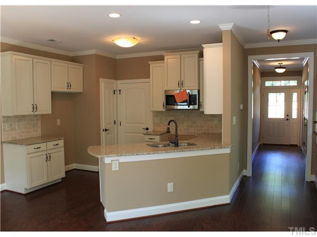 2101 Scarlet Maple Drive Raleigh, NC 27606 - Photo 6 of 18 a kitchen with sink cabinets and wooden floor