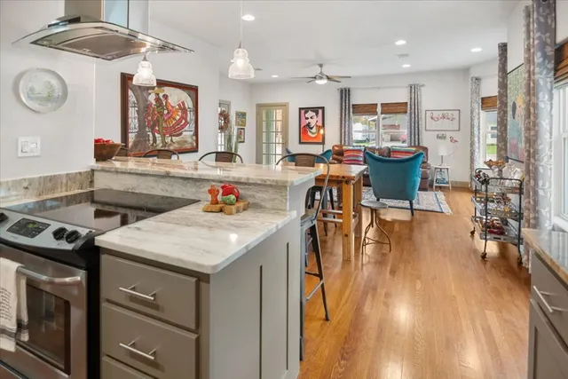 a open kitchen with stainless steel appliances granite countertop a stove and a table with chairs