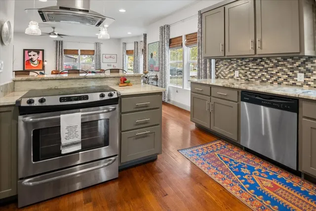 a kitchen with stainless steel appliances granite countertop a stove a sink and a microwave