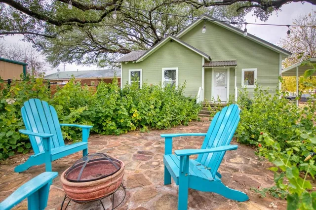 a backyard of a house with table and chairs potted plants