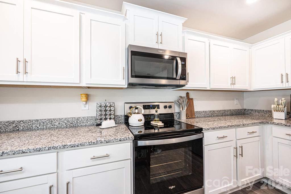 1808 Bright Hope Lane Dallas, NC 28034 - Photo 18 of 44 a kitchen with granite countertop white cabinets and a stove a oven with white countertops