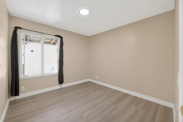a view of empty room with wooden floor