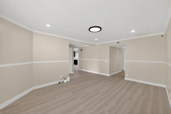 an empty room with wooden floor and window