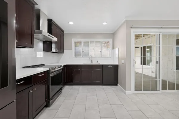 a kitchen with stainless steel appliances granite countertop a sink and dishwasher a refrigerator with wooden cabinets