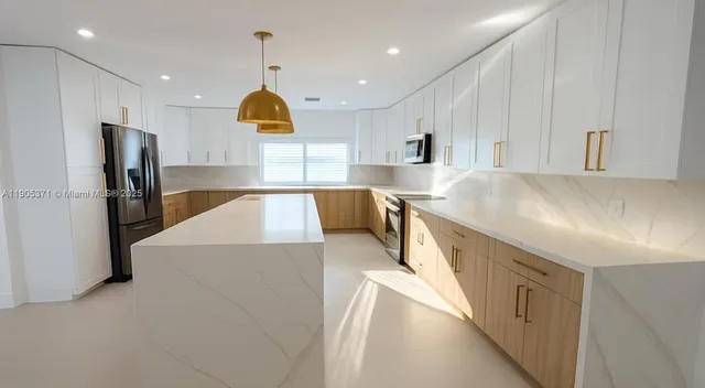 a kitchen with stainless steel appliances granite countertop a sink and a refrigerator