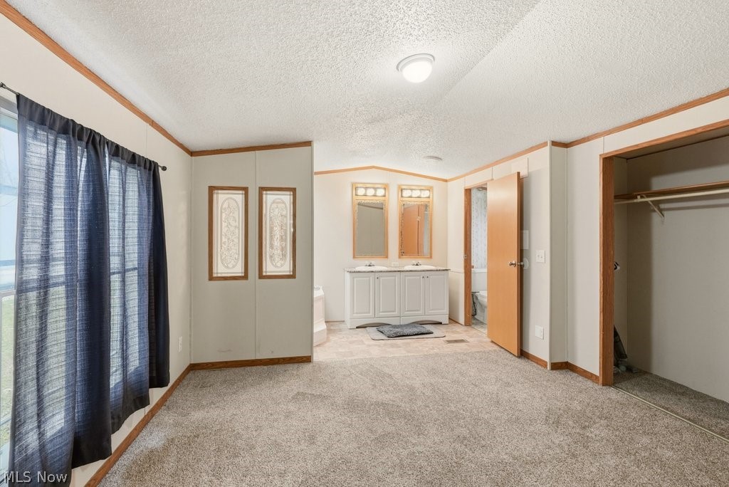 6507 Robby Lane Ravenna, OH 44266 - Photo 14 of 25 Unfurnished bedroom with crown molding, carpet, and a closet