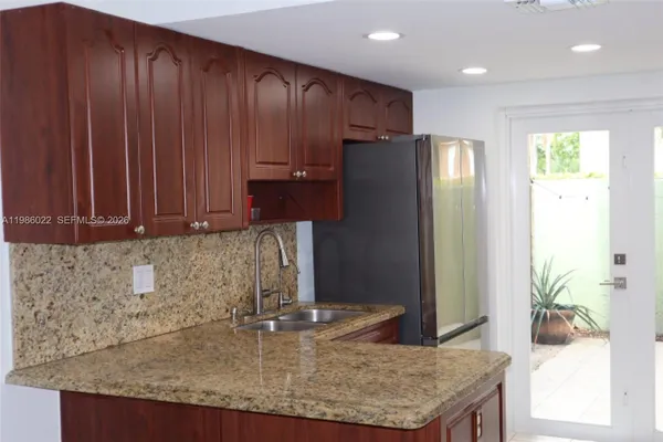 a kitchen with kitchen island granite countertop wooden cabinets and a counter top space