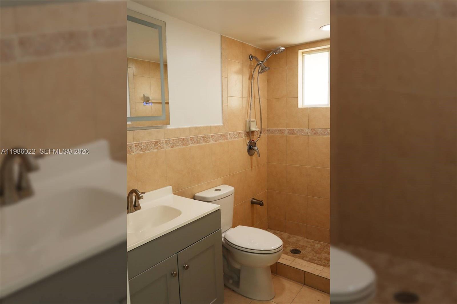 10101 West Okeechobee Road, Unit 12101 Hialeah Gardens, FL 33016 - Photo 7 of 12 a bathroom with a toilet a sink and mirror