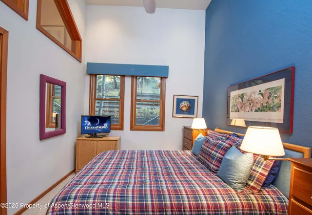 a bedroom with a bed and a lamp on dresser