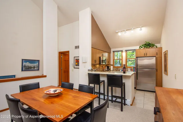 a kitchen with a table chairs and refrigerator
