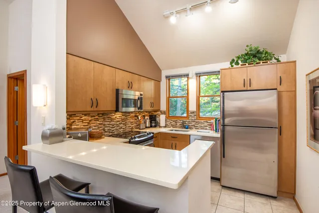 a kitchen with kitchen island a refrigerator stove and sink